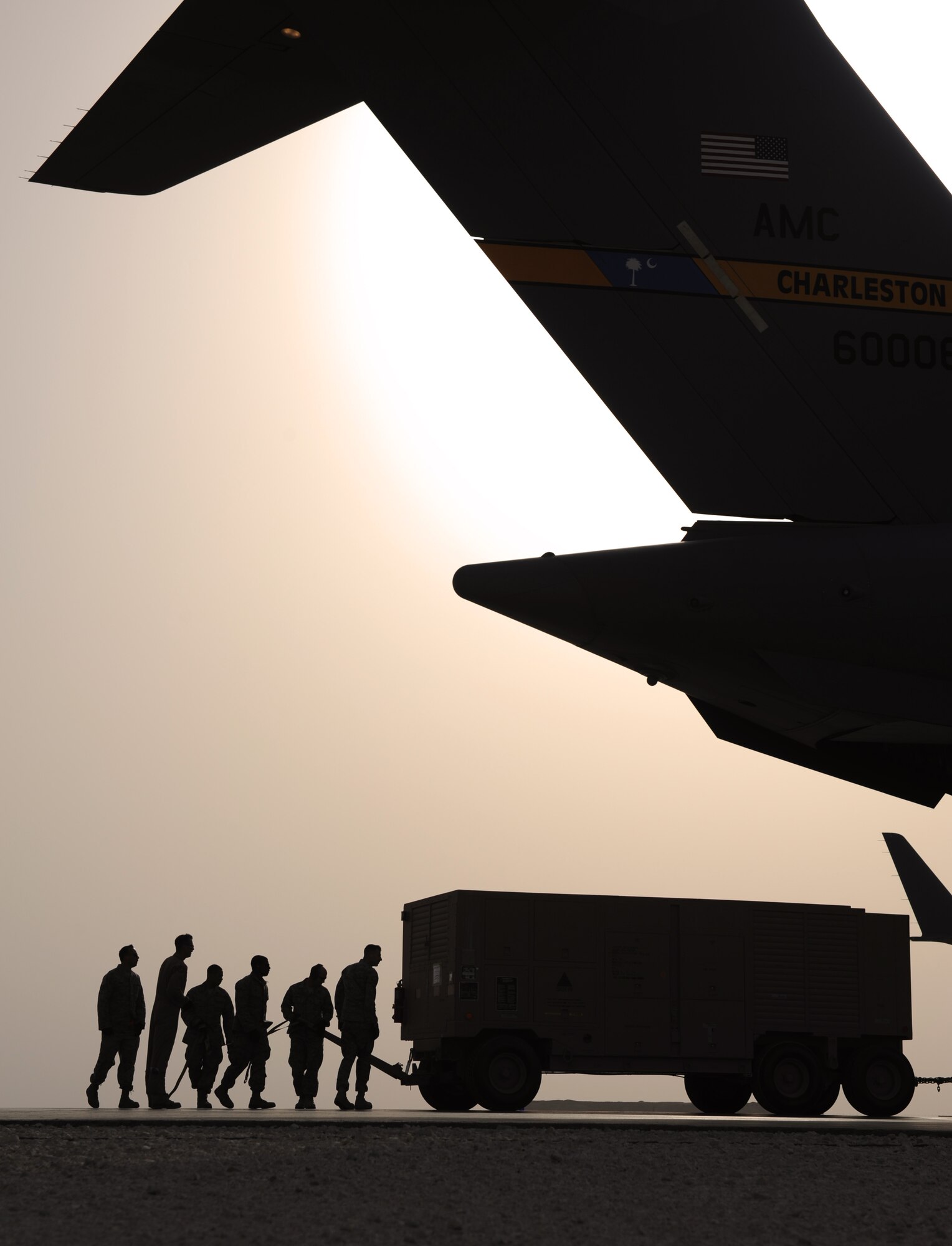 SOUTHWEST ASIA – Airmen from the 8th Expeditionary Air Mobility Squadron ramp section steer a generator as it is pulled into a C-17 Globemaster III here Feb. 11, 2012. The Airmen are air transportation specialists from the 8th EAMS ramp section, which loads aircraft with cargo after the cargo processing section has prepped the cargo for transportation. (U.S. Air Force photo/Staff Sgt. Nathanael Callon)