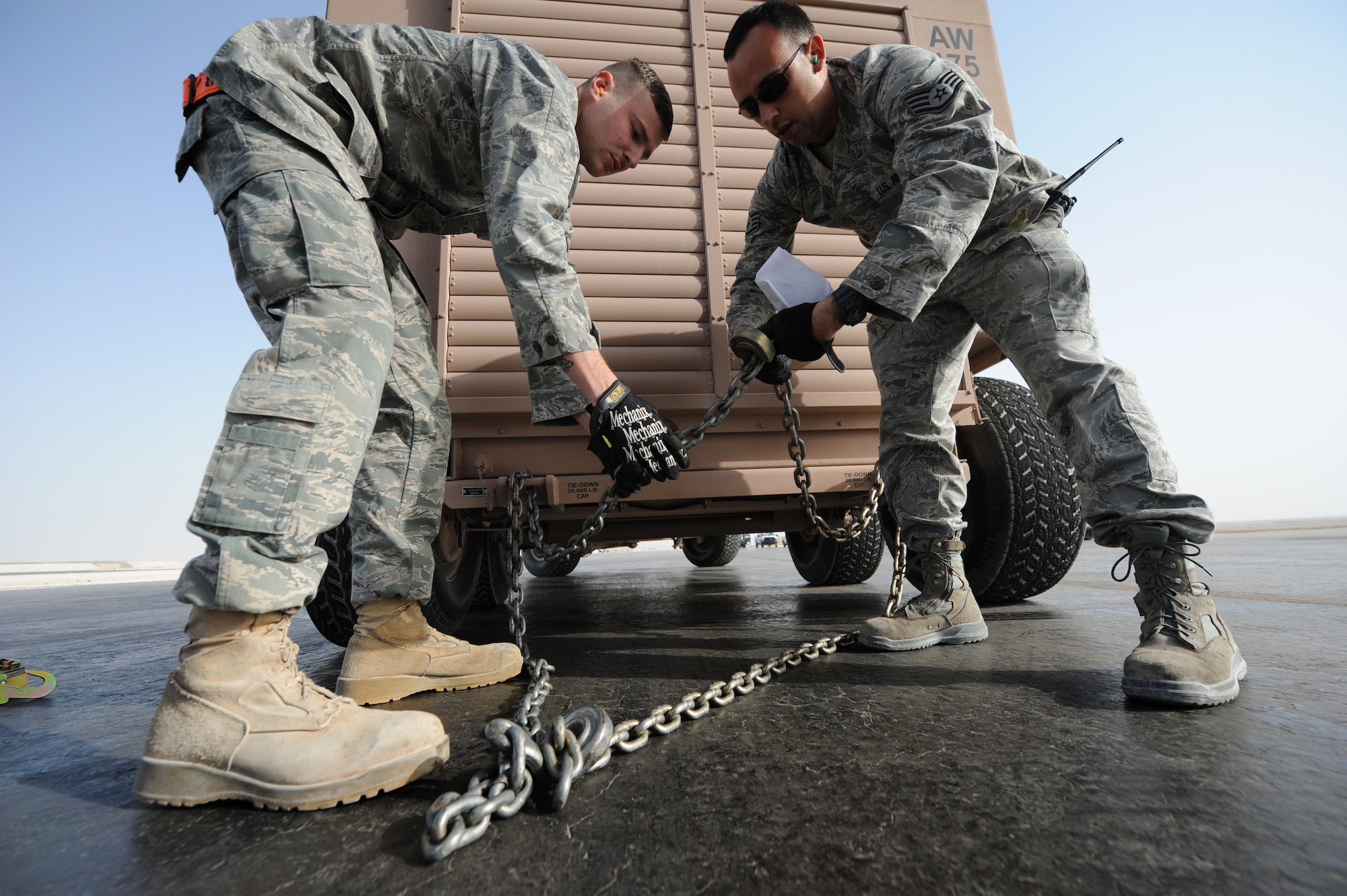 SOUTHWEST ASIA – Airman 1st Class Michael Bethell and Staff Sgt. Walter Towers, 8th Expeditionary Air Mobility Squadron air transportation specialists, prepare a towing chain for a generator before it is loaded into a C-17 Globemaster III here Feb. 11, 2012. Bethell and Towers belong to the 8th EAMS ramp section, which is responsible for loading and unloading cargo on aircraft. Bethell is a native of Long Island, N.Y., and Towers is a native of Vega Baja, Puerto Rico. (U.S. Air Force photo/Staff Sgt. Nathanael Callon)