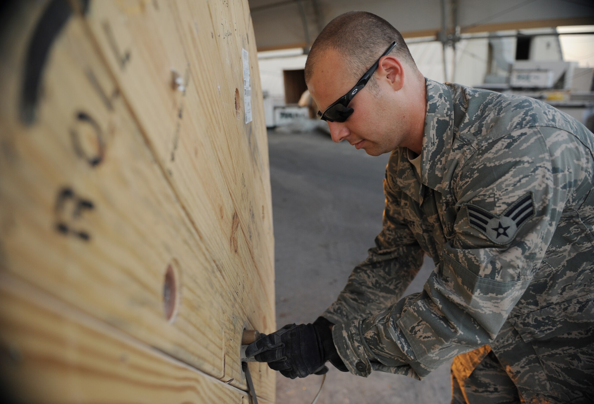 SOUTHWEST ASIA – Senior Airman Jonathan Woodruff, 8th Expeditionary Air Mobility Squadron air transportation specialist and native of Griffin, Ga., threads a strap through a hole in a roll of copper wire here Feb. 10, 2012. Woodruff is assigned to the cargo processing section, which prepares cargo for the ramp section, who moves the cargo to the aircraft. (U.S. Air Force photo/Staff Sgt. Nathanael Callon)