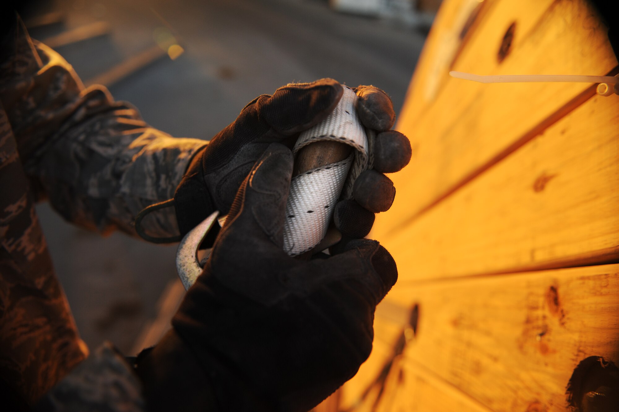 SOUTHWEST ASIA – Senior Airman Jonathan Woodruff, 8th Expeditionary Air Mobility Squadron air transportation specialist and native of Griffin, Ga., prepares to thread a strap through a hole in a roll of copper wire here Feb. 10, 2012. Woodruff is assigned to the cargo processing section, which prepares cargo for onward movement to forward operating locations in Southwest Asia. (U.S. Air Force photo/Staff Sgt. Nathanael Callon)