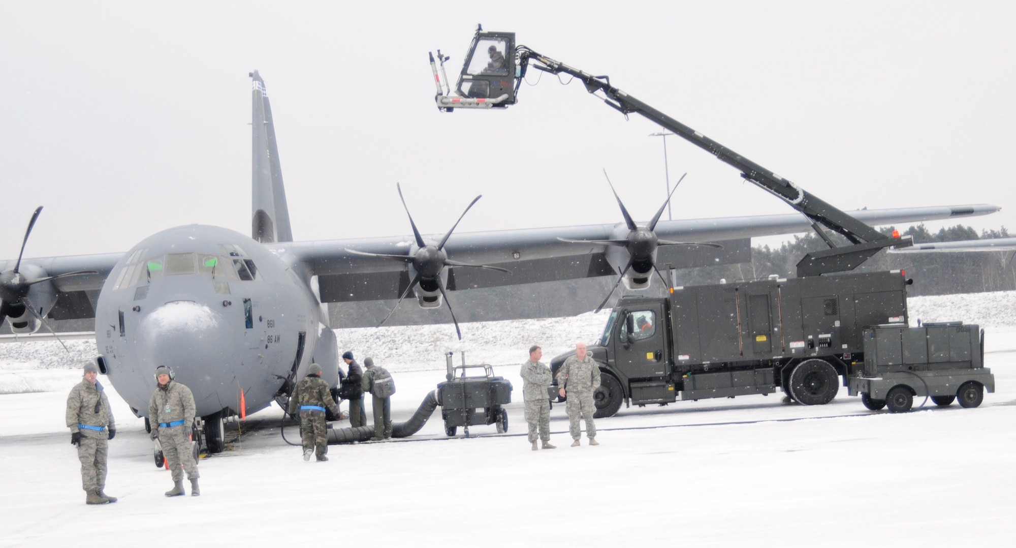 Maintainers from the 86th Maintenance Squadron de-ice a C-130J Feb. 10, 2012. The maintainers worked countless hours in preparation for the 37th Airlift Squadron's mass airdrop. The airdrop commemorated 70 years of combat airlift capabilities for the 37th AS. . (U.S. Air Force photo by Airman 1st Class Trevor Rhynes) 
