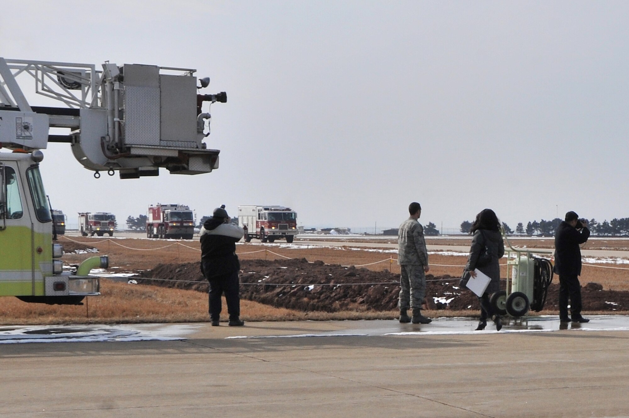 Photojournalists from Defense Times Korea take photos of Airmen from the 8th Civil Engineer Squadron’s fire department, during a drill at Kunsan Air Base, Republic of Korea, Feb. 10, 2012.  Kunsan Airmen will be featured in the March issue of Defense Times Korea. (U.S. Air Force photo by Senior Airman Brittany Y. Auld/Released)