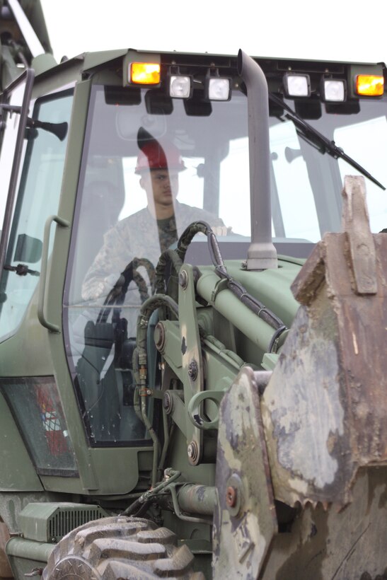 Lance Cpl. Thomas R. Swortchek, Marine Wing Support Squadron 171 heavy equipment operator, sits in the cabin of a John Deere TRAM 624KR Tractor, Rubber Tired, Articulated Steering, Multi-purpose vehicle after clearing away debris and a broken down chainlink fence on the north side of the station here Feb. 15 with Seabees from Headquarters and Headquarters Squadron. Project which are small in scale, such as the demolition of this fence, are not done as often by Seabees, as more often than not, in larger battalions, they build runways and forward operating bases but are capable of doing any project regardless of the size. Only 12 Seabees are aboard the station.