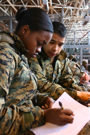Lance Cpl. Ofni D. Arellano, a automotive organizational mechanic (left) helps show Lance Cpl. Jacklyn E. Erhunmwunsee, a supply administrative specialist, tips on passing information over the radio during a radio communication class here Feb. 16.