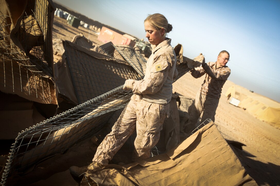 Lance Cpl. Jennifer Herman, a combat engineer with Alpha Company, 9th Engineer Support Battalion, and a native of Madison, Wis., helps move a piece of a HESCO barrier at Firebase Saenz, Helmand province, Dec. 14. FB Saenz is the first of several patrol bases being demilitarized by the Marines of 9th ESB throughout the month of December.