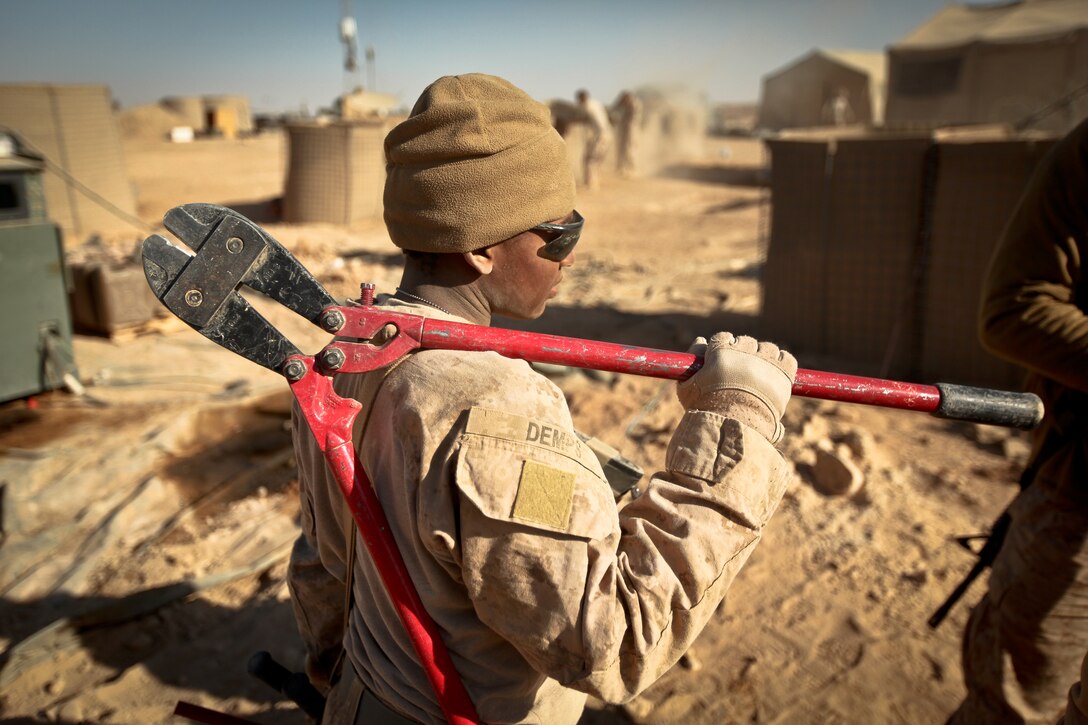 Lance Cpl. Tameka Demps, a combat engineer with Alpha Company, 9th Engineer Support Battalion, and a native of Las Vegas, Nev. holds a pair of bolt cutters as she looks for a HESCO barrier to dismantle at Firebase Saenz, Helmand province, Dec. 14. FB Saenz is the first of several patrol bases being demilitarized by the Marines of 9th ESB throughout the month of December.