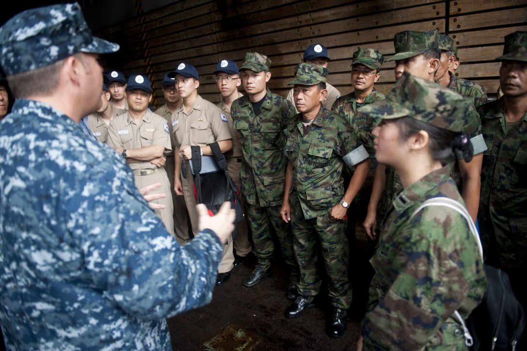 Kenneth Cutts, district director for U.S. Rep. Sanford D. Bishop Jr., 2nd district of Georgia, hands a Congressional   Record to Chief Warrant Officer 3 Christian Flores, band officer, as Maj. Gen. Charles L. Hudson, commanding general, Marine Corps Logistics Command, watches, Tuesday, at the Albany Municipal Auditorium in Albany, Ga.