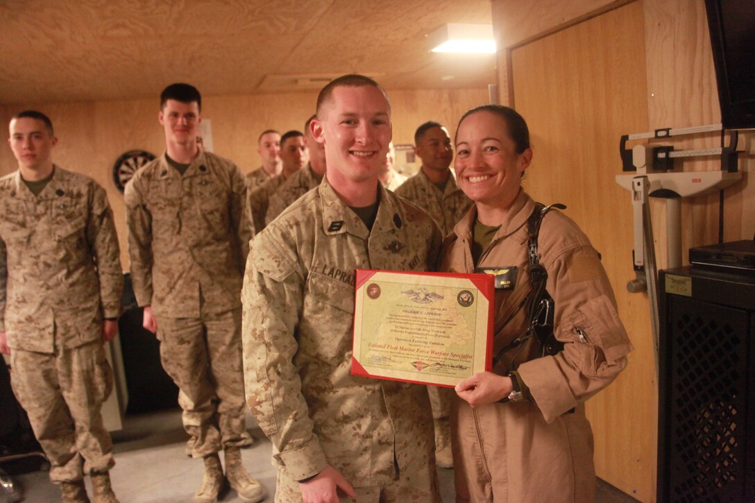 Seaman Chase Lapradd, a corpsman attached to 2nd Marine Aircraft Wing (Forward), and a native of Drakes Branch, Va., receives his Fleet Marine Force qualification certificate from Cmdr. Erica Miller, the 2nd Marine Aircraft Wing (Forward) flight surgeon, at Camp Leatherneck, Afghanistan, Feb. 16. The Fleet Marine Force qualification is issued to Sailors who are trained and qualified to perform duties in support of U.S. Marine Corps operations, and can only be issued by Marine commanding generals or commanding officers of regimental-level commands. More than 50 Sailors attached to 2nd Marine Aircraft Wing (Forward) have earned the qualification in the past year.