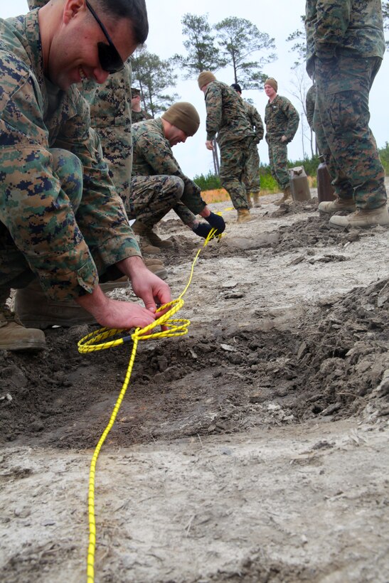 EOD technicians place detonation cord into holes Feb. 16 at the Cherry Point EOD range. The technicians spent all day at the range preparing for the air show and detonated various explosives.