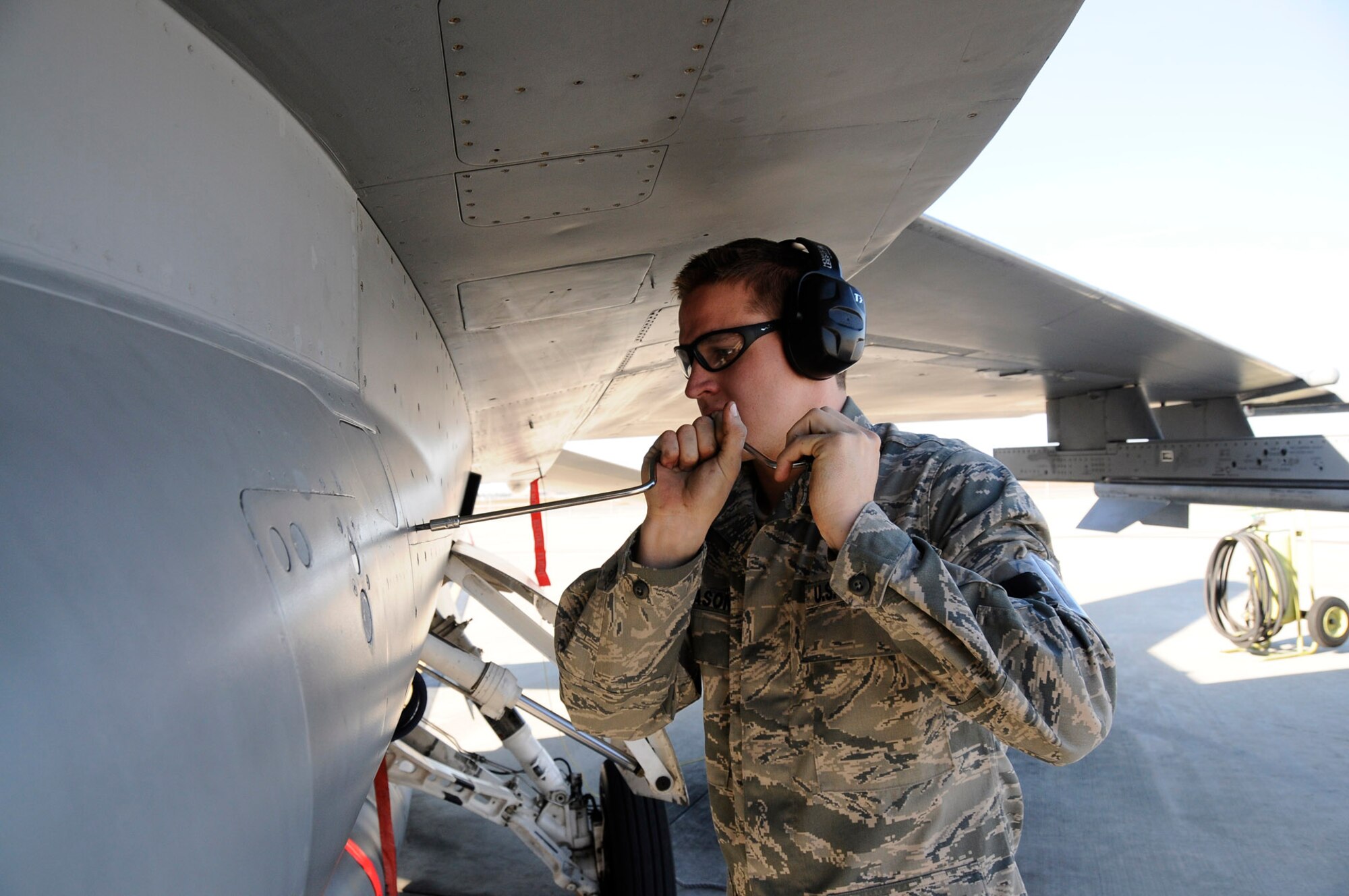 Airman 1st Class David Hutchason, an F-16 crew chief with the 144th Maintenance Group, California Air National Guard, prepares to remove an access panel on the F-16 Fighting Falcon after its afternoon mission on February 5, 2012.  (Air National Guard photo by Tech. Sgt. Charles Vaughn)