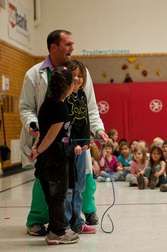 Capt. Bradley Harrelson, 28th Medical Operations Squadron dentist, also known as Dr. Juggles, demonstrates the proper way to floss at Horace Mann Elementary School in Rapid City, S.D., Feb. 9, 2012. Dr. Juggles encouraged the children’s engagement in the performances to make learning about oral hygiene fun and interesting. (U.S. Air Force photo by Airman 1st Class Kate Thornton/Released) 