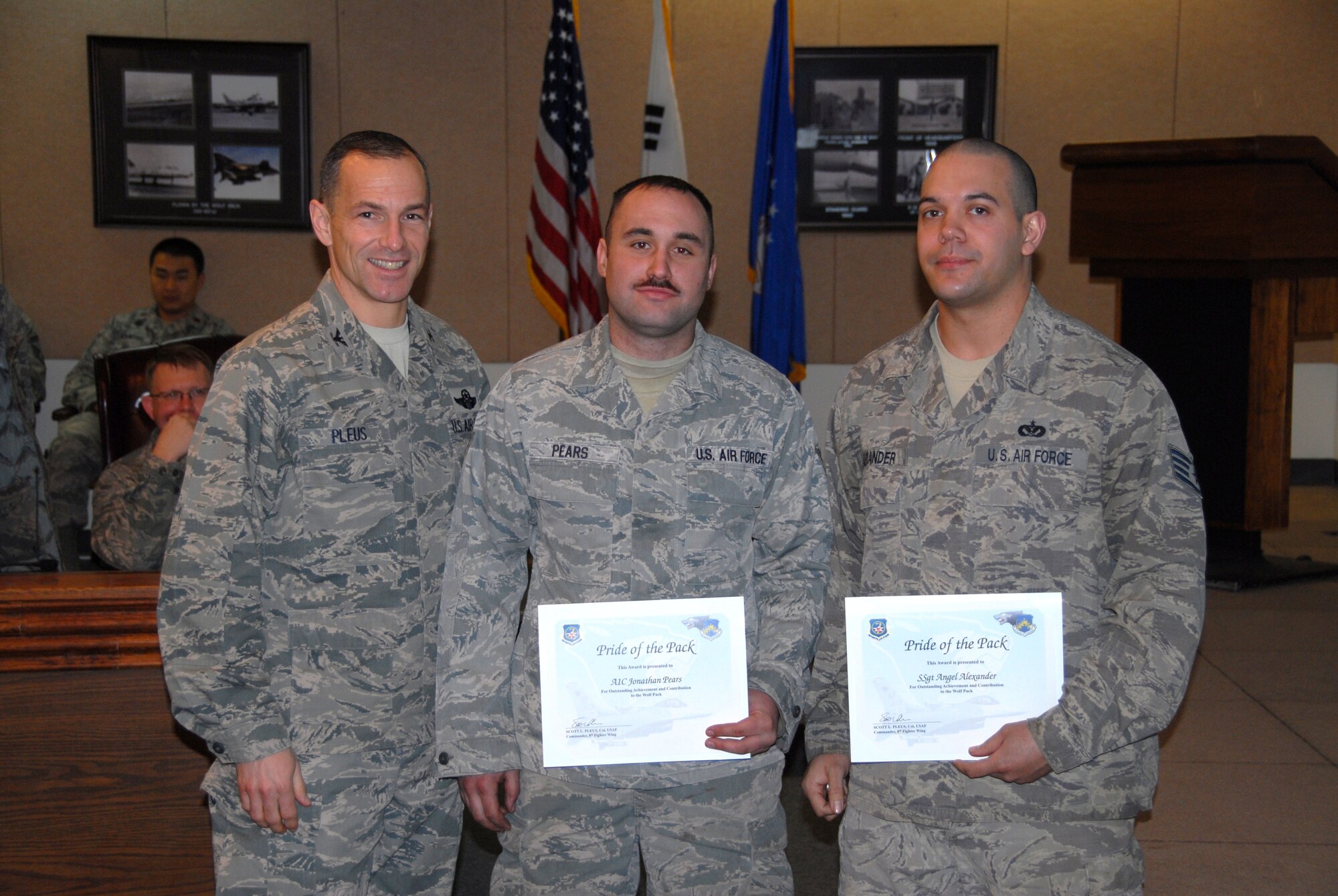 Col. Col Scott L. Pleus, 8th Fighter Wing commander, presents Airman 1st Class Jonathan Pears (middle) and Staff Sgt. Alexander Angel, 8th Civil Engineer Squadron heating, ventilation, air conditioning and refrigeration technicians, with Kunsan’s Pride of the Pack, which recognizes the outstand work Airmen do every day. (U.S. Air Force photo by Capt. Omar Villarreal/ Released) 