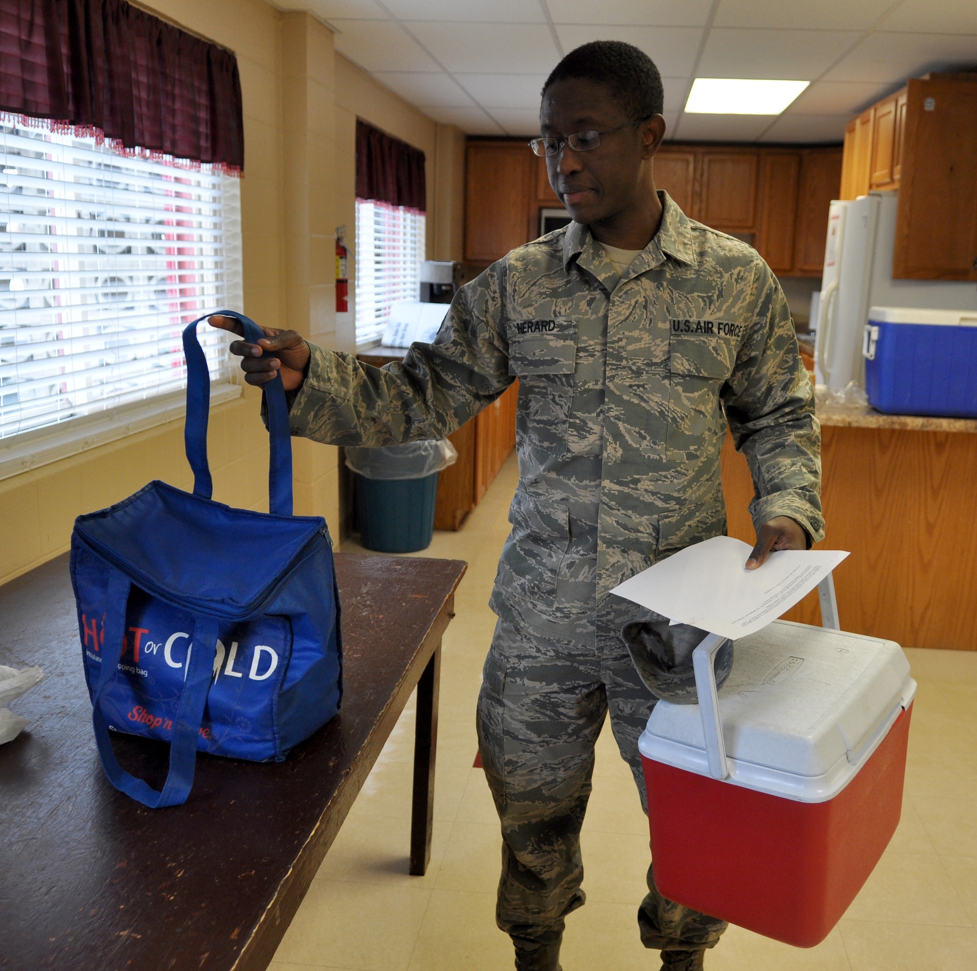 Staff Sgt. Joseph Herard, 375th Logistics Readiness Squadron vehicle management and analysis, picks up food and directions prior to delivering meals throughout Belleville. Volunteers from Scott deliver the majority of meals to 95 people a day.(U.S. Air Force photo/Senior Airman Amber R. Kelly-Herard)