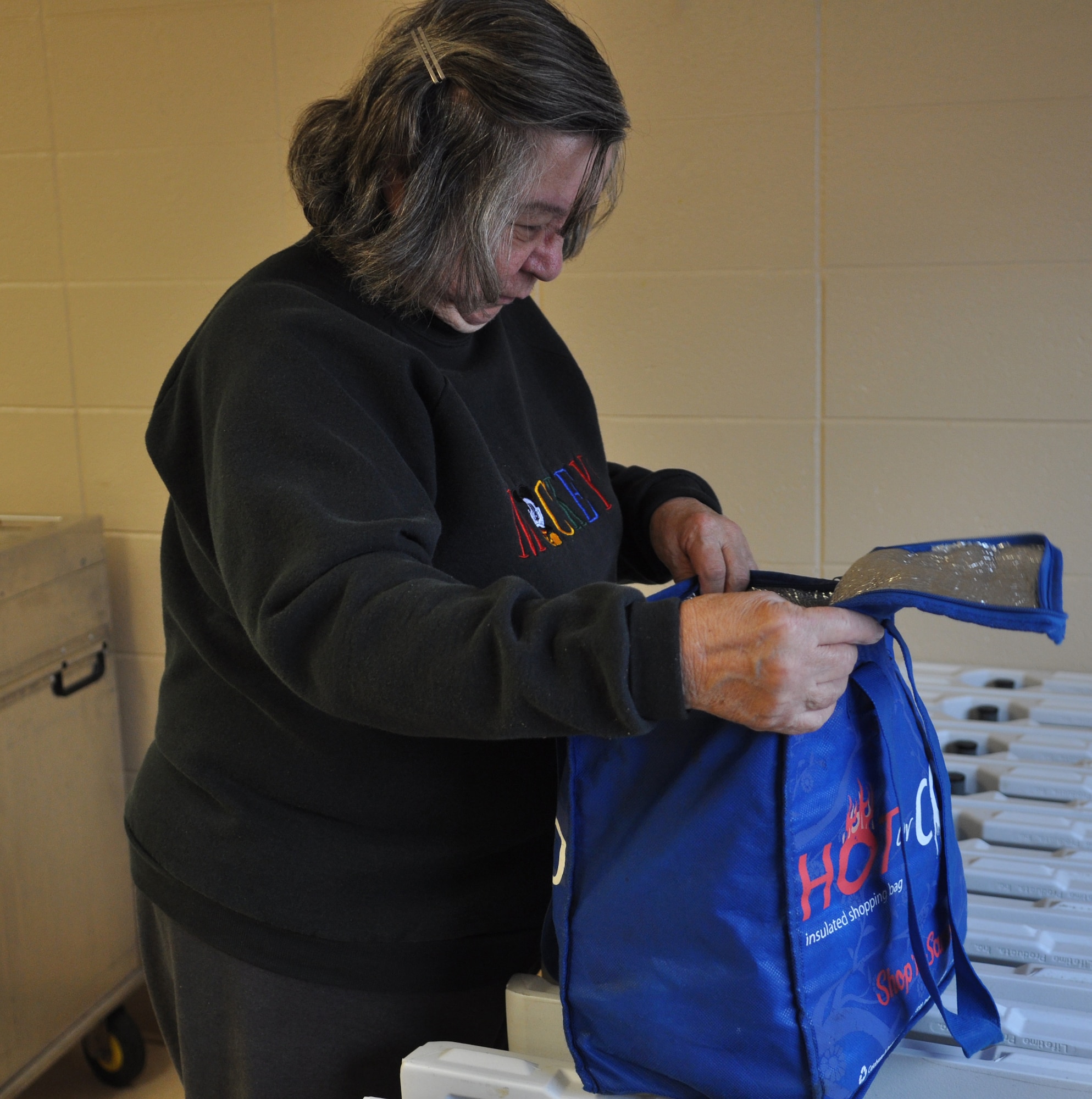 Meals on Wheels volunteer, Delores Boderdick, prepares hot meals for
delivery. Volunteers for the Meals on Wheels program deliver hot food,
bread, milk and dessert to about 500 elderly citizens a day in St. Clair and
Madison Counties. (U.S. Air Force photo/Senior Airman Amber R. Kelly-Herard)
