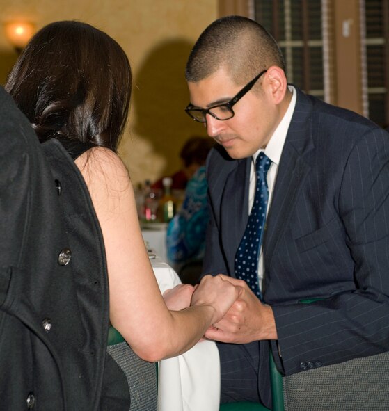 Capt. Eduardo Cervantes, 2nd Medical Support Squadron, and his wife, Mary, hold hands during dinner on Barksdale Air Force Base, La., Feb. 14. The Cervante's celebrated their first Valentine's Day as a married couple. (U.S. Air Force photo/Airman 1st Class Benjamin Gonsier)(RELEASED)