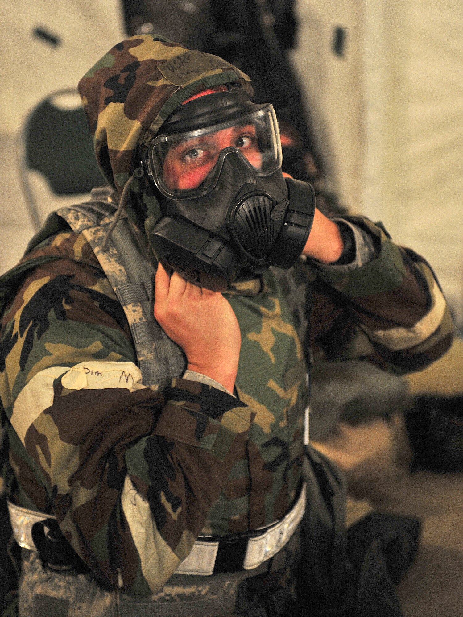 U.S. Air Force Master Sgt. Jason Chrisman, 23d Force Support Squadron team chief, responds to an alarm red by quickly putting on his gas mask and gloves and dropping to the floor for protection during a phase II operation readiness exercise at Moody Air Force Base, Ga., Feb. 15, 2012. Chrisman not only responded to the alarms but ensured all his Airmen were following the right procedures and continually checked up on them. (U.S. Air Force photo by Staff Sgt. Stephanie Mancha/Released)