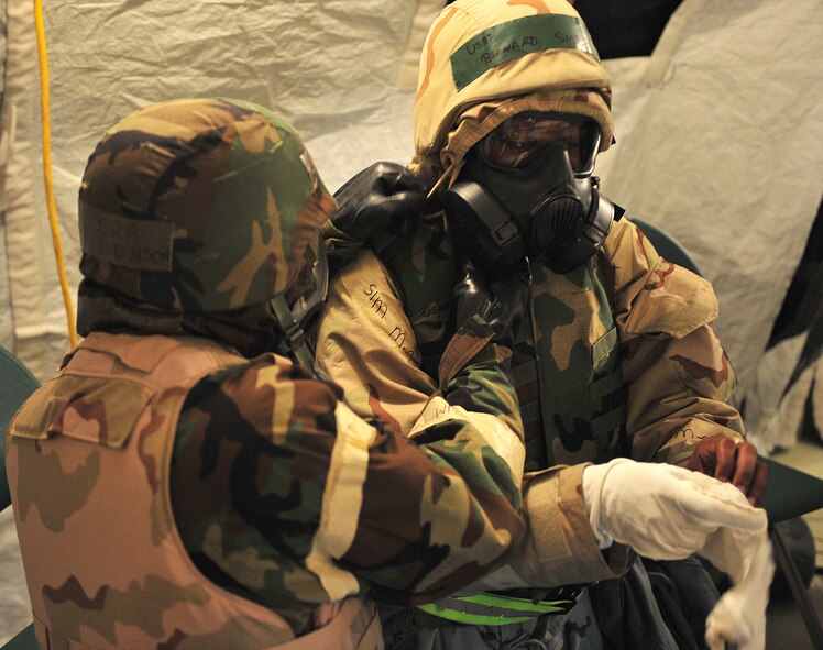 U.S. Air Force Airman 1st Class Rangel Robinson, left, 23d Force Support Squadron personnel support for contingency operations team member, and Tech. Sgt. Bernard Smith,23d FSS NCO in-charge of PERSCO, perform buddy checks in alarm red during a phase II operation readiness exercise at Moody Air Force Base, Ga., Feb. 15, 2012. Performing buddy checks is important to ensure both members are properly wearing their gear and can reduce the risk of contamination. (U.S. Air Force photo by Staff Sgt. Stephanie Mancha/Released)