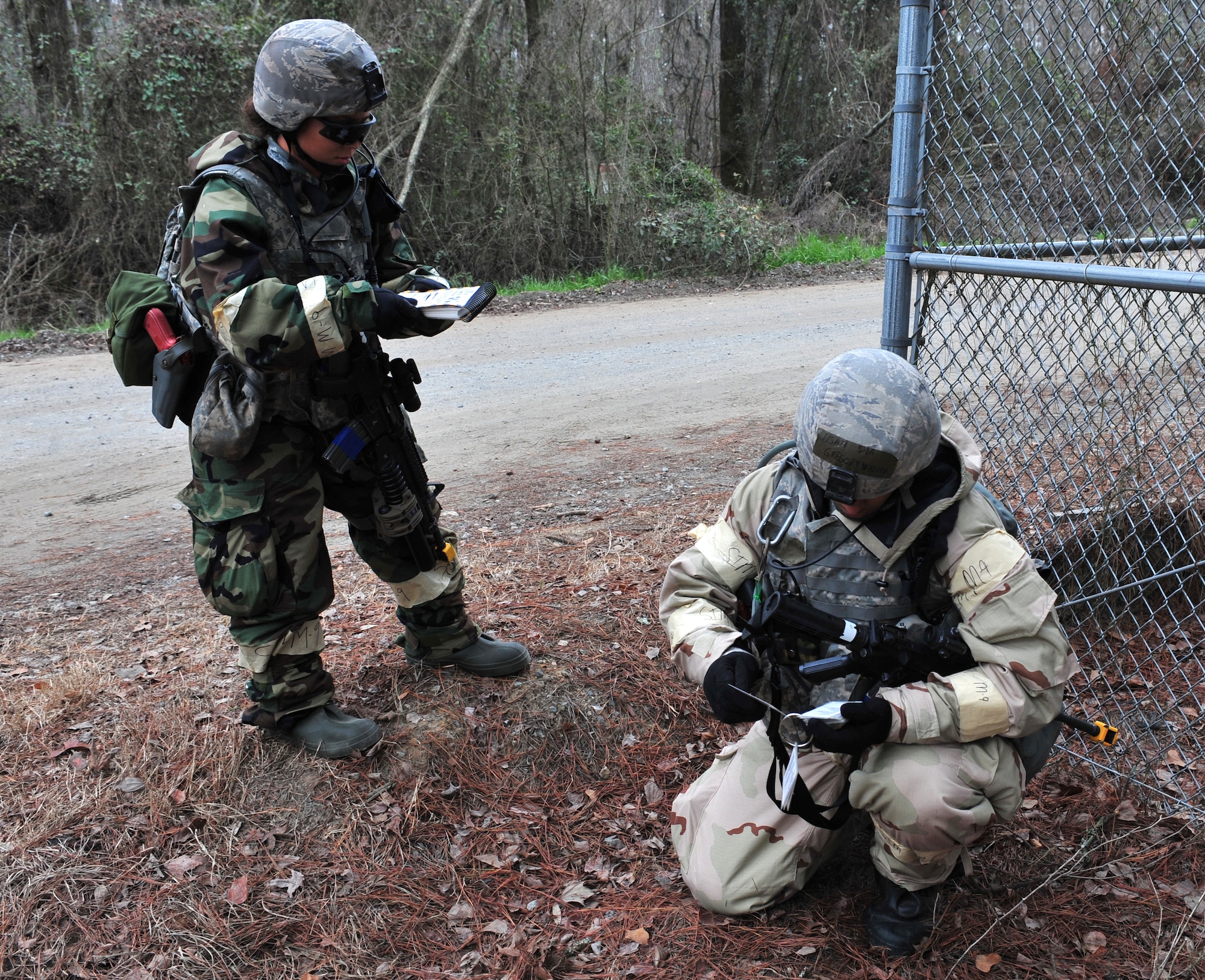 U.S. Air Force Airman 1st Class Angela Jones and Senior Airman Gregory Walker, both fire team members with the 23d Security Forces Squadron, look through their Airmen’s manual  to find the proper way to report a nine line on the type of improvised explosive device found in a vehicle during a phase II operation readiness exercise at Moody Air Force Base, Ga., Feb. 15, 2012. The security forces members were being evaluated on their understanding of procedures and how to act under certain situations. (U.S. Air Force photo by Staff Sgt. Stephanie Mancha/Released)