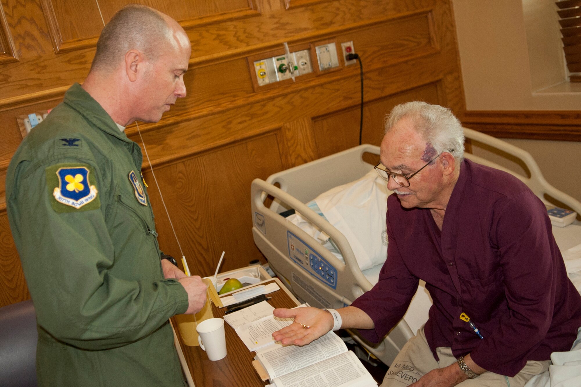 U.S. Air Force Col. Jonathan Ellis, 307th Bomb Wing commander, gives a 307th BW lapel pin to Bill Phillips, Overton Brooks Veterans Administration Medical Center, Shreveport, La., Feb. 15, 2012. Phillips, a patient at the medical center, was stationed at Barksdale Air Force Base, La., in 1966, and is a former B-52 armament and electronics technician. (U.S. Air Force photo by Master Sgt. Greg Steele/Released)