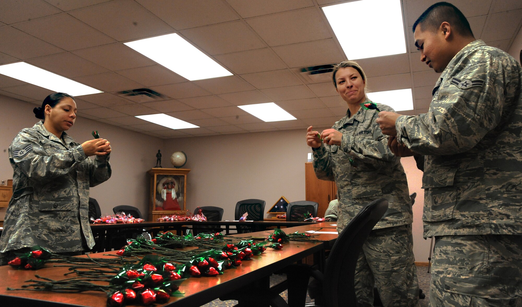 Staff Sgt. Nataly Baron, 319th Force Support Squadron, Staff Sgt. Mary Cisneros and Airman 1st Class Adrian Thompson, members of the 319th Civil Engineer Squadron, help assemble “Sweetheart Roses” at the Airman Leadership School on Feb. 14 on Grand Forks Air Force Base, N.D.  The Sweetheart Roses came from Operation Cupid which helped raise $291 for Network 56.  Network 56 is a professional organization with the intentions of reaching out to the community and making a difference in themselves and others. (U.S. Air Force Photo by Airman 1st Class Xavier Navarro) 