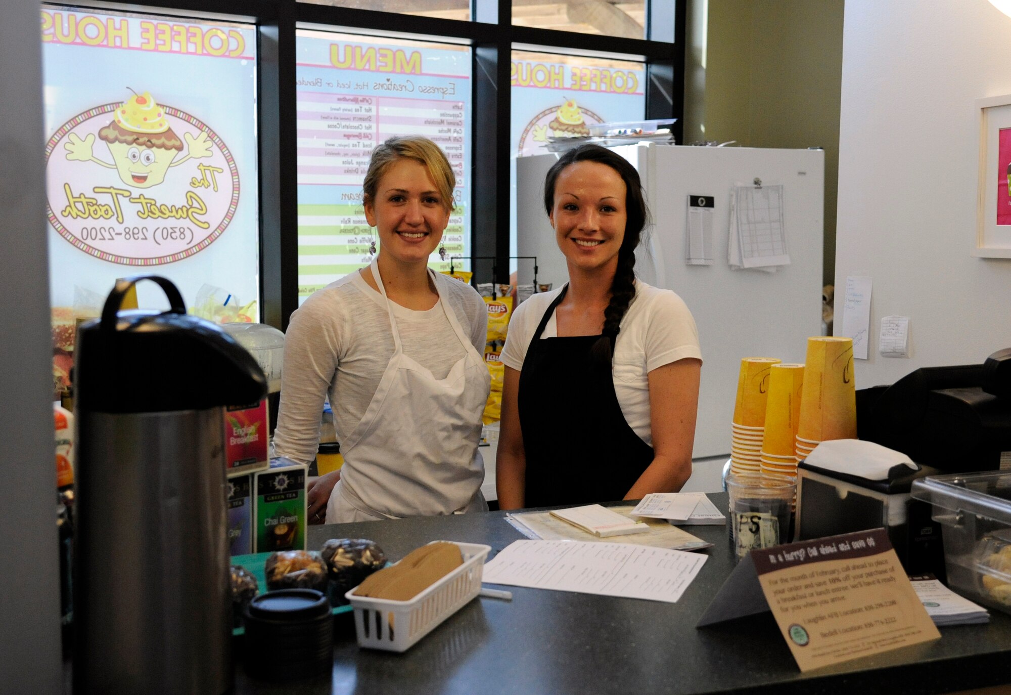 LAUGHLIN AIR FORCE BASE, Texas – Candace Hough, The Sweet Tooth assistant manager, and Erin Penner, a barista for The Sweet Tooth, pose behind the counter of The Sweet Tooth in Laughlin’s Education Center Feb. 15. The Café opened for business in January and offers customers a variety of food and drinks.  (U.S. Air Force photo/Airman 1st Class Nathan L. Maysonet)