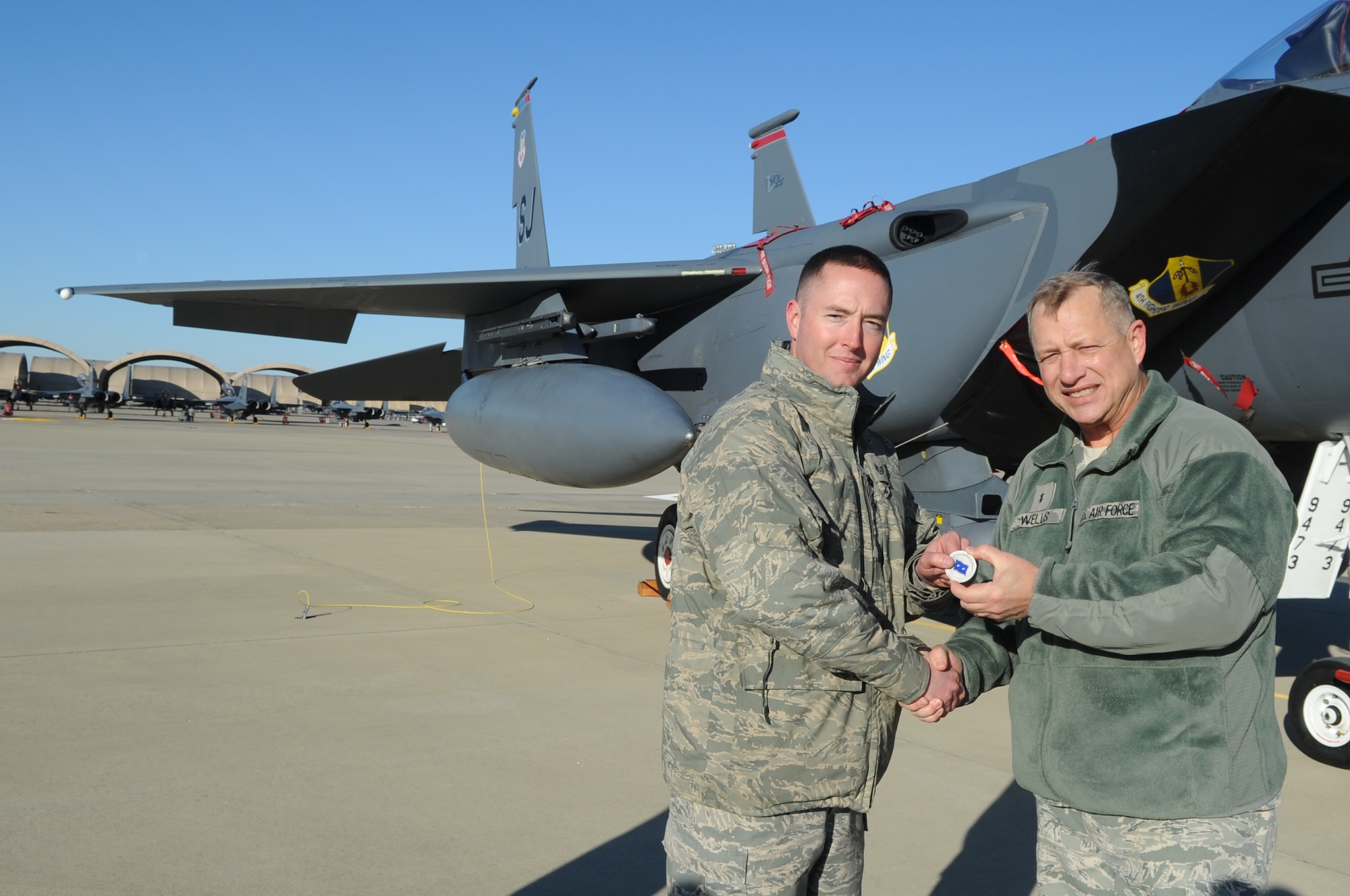 U.S. Air Force Staff Sgt. Travis Lechleiter receives a coin from U.S. Air Force Maj. Gen. Lawrence Wells for being the dedicated crew chief of the wing’s flagship competition overall winning team at Seymour Johnson Air Force Base, N.C., Jan. 13, 2012. Wells, 9th Air Force commander, visited the base to acknowledge Airmen for their outstanding performance during the past year. Lechleiter is a 333rd Aircraft Maintenance Unit dedicated crew chief who hails from Redding, Calif. (U.S. Air Force photo/Senior Airman Gino Reyes/Released)