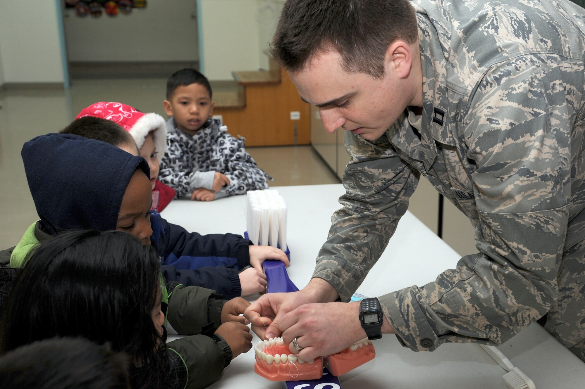 U.S. Air Force Capt. Jon Vandewalker, 35th Dental Squadron, teaches Sure Start students at Sollars Elementary School how to floss their teeth during a National Children's Dental Health Month presentation at Misawa Air Base, Japan Feb. 16, 2012. Throughout the month, members of the 35 DS will teach children the importance of brushing and flossing their teeth as well as limiting sugary and starchy snacks that bacteria thrive on. (U.S. Air Force photo by Tech. Sgt. Marie Brown/Released)
