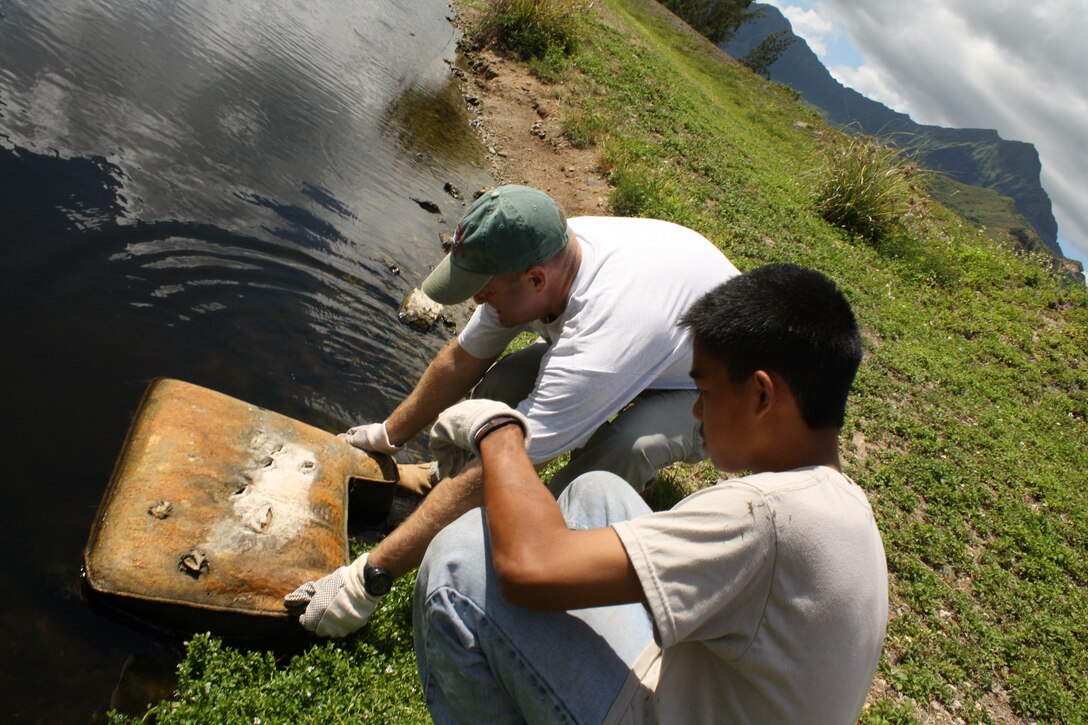 Honolulu District Commander Lt. Col. Doug Guttormsen pulls a chair cushion out of the marsh as Volunteers cleaned up Kaha Garden at Kawainui Marsh City Park in Kailua for National Public Lands Day on Saturday, September 24, 2011.