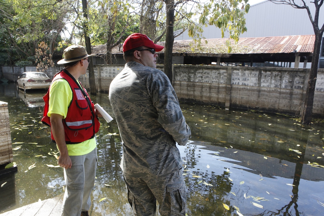 U.S. Army Corps of Engineers Chief of Civil Works-Technical Branch Mike Wong (left) with Capt. Stiles, USAF, 36th CRG from Guam; surveying flood waters at Royal Thai Air Force base, Don Meung Airport, near an engine maintenance building in Thailand.