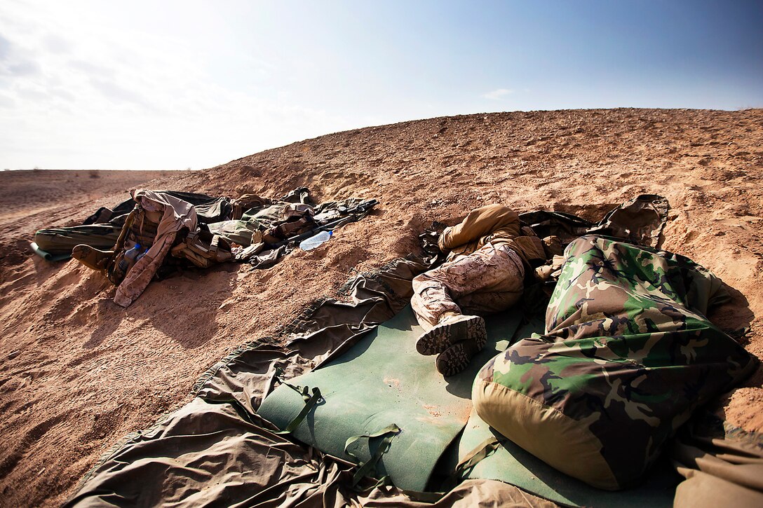U.S. Marine Lance Cpl. Christopher Rico rests in a foxhole at his platoon's defensive position after a security patrol during Operation Shahem Tofan Eagle Storm in the Garmsir district, Helmand province, Afghanistan, Feb. 12, 2012. Rico is a mortarman assigned to Weapons Company, 3rd Battalion, 3rd Marine Regiment.