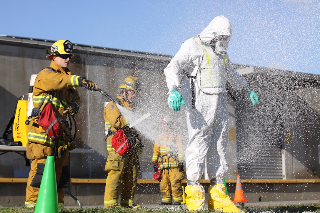 Matt McCleod, a Marine Corps Base Camp Pendleton firefighter, sprays decontaminant on a fellow firefighter during a field training exercise on Camp Pendleton, Feb. 16. The FTX was the final training day of a six-week long course to renew California Emergency Management Agency certification.