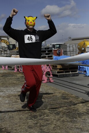 J. Gage Karwick runs through the Gokukan five kilometer fun run finish line with a Pikachu mask behind the IronWorks Gym here Feb. 17. Gokukan, literally translated as “extreme cold” in Japanese, is given to this run, which takes place here annually and always during February.