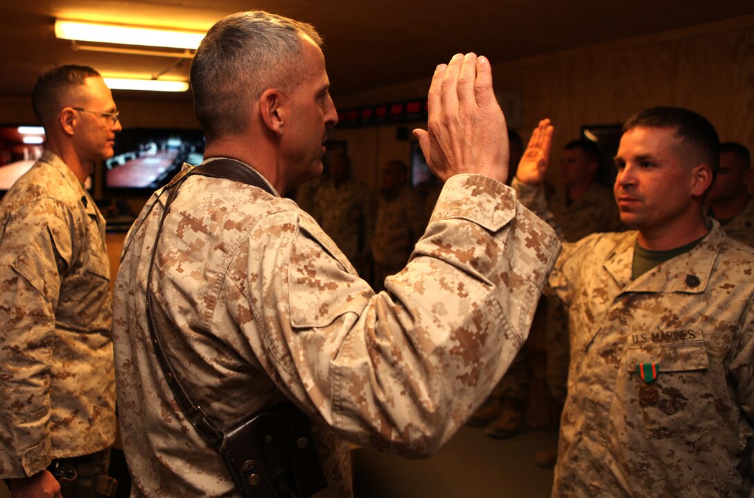 Brig. Gen. Michael G. Dana, 2nd Marine Logistics Group (Forward) commanding general, recites the oath with Staff Sgt. Derek A. Smoak, a tactical vehicle license examiner with 2nd MLG (Fwd.), during his promotion ceremony Feb. 1, 2012, aboard Camp Leatherneck, Afghanistan. On the other side of the world, the 2nd MLG command helped his wife, Michelle L. Smoak, witness her husband’s promotion and award ceremony through a teleconference call.