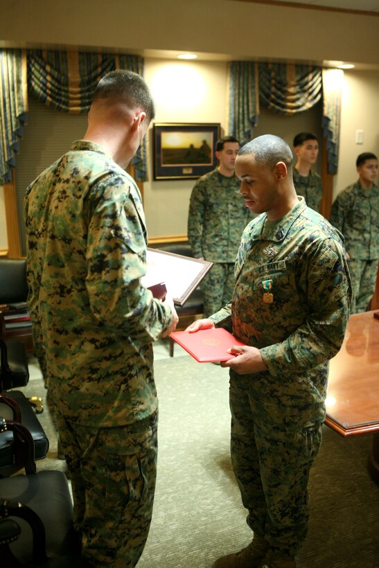 Col. Mark Hollahan, 2nd Marine Logistics Group commanding officer, presents Petty Officer 2nd Class Donnell Proctor, a hospital corpsman with the 2nd MLG from Baltimore, with the Navy and Marine Corps Achievement Medal for earning the title of Junior Sailor of the Year during a ceremony Jan. 20, 2012, aboard Camp Lejeune, N.C.  Proctor also received an engraved knife as well as a Letter of Appreciation on behalf of the command in recognition for his year-long efforts. (Photo by Cpl. Bruno J. Bego)  