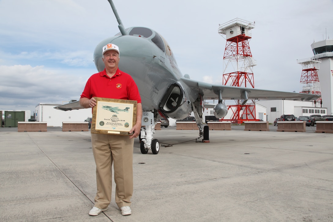 Retired Col. Wayne Whitten holds a plaque commemorating the delivery of the first EA-6B Prowler to MCAS Cherry Point, which took place Feb. 17, 1977. Whitten was a member of the aircrew that delivered the aircraft here 35 years ago. The Prowler behind him is the same he delivered to Cherry Point and the only EA-6B to never serve in a Navy electronic warfare squadron.