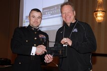 Recruiting Station Twin Cities Commanding Officer Maj. Kenneth Gawronski presents Minnetonka High School football coach Dave Nelson with the Semper Fi Award at the Minneapolis Glazier Clinic Feb 17. The intent behind the Semper Fi Coach Award is to recognize a high school football coach who exemplifies the Marine Corps motto: Semper Fidelis. A Semper Fi Coach is not defined by winning records or championship titles, but rather as a man who creates a legacy of intentional leadership.