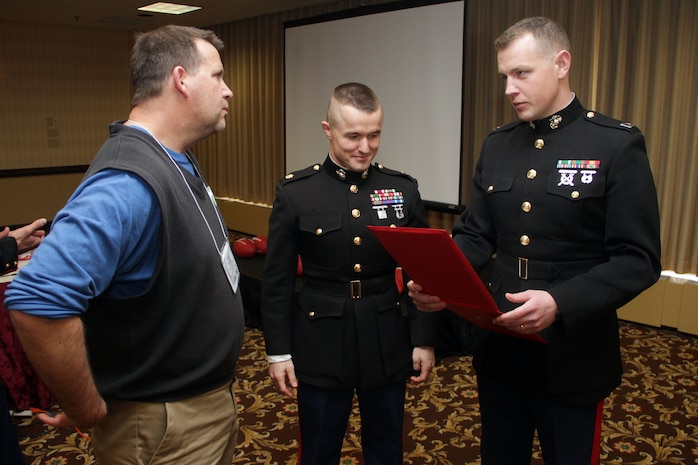Recruiting Station Twin Cities executive and commanding officers Capt. Timothy O'Neil and Maj. Kenneth Gawronski present Eagan High School football coach Rick Sutton with a letter of appreciation for speaking about his educators' workshop experience while attending the Minneapolis Glazier Clinic Feb 17.