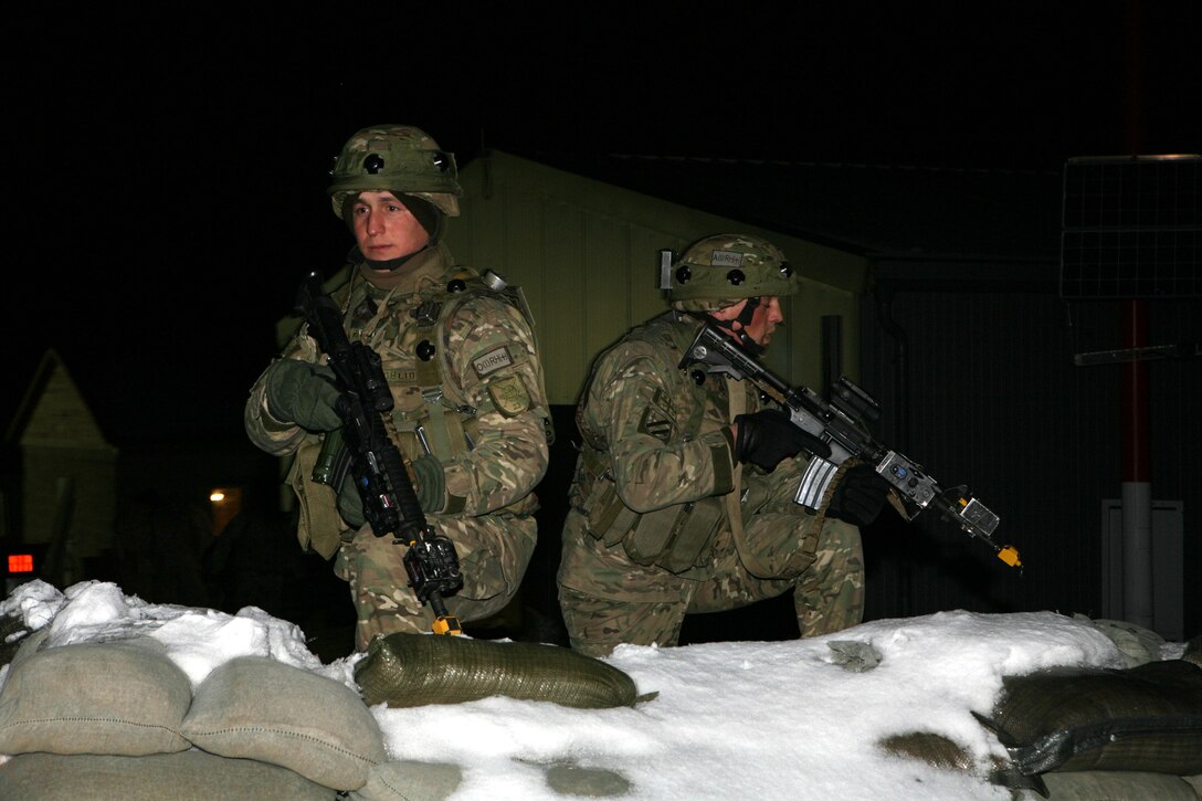 Two Georgian soldiers from the 23rd Light Infantry Battalion keep a watchful eye on the surrounding area after a car bomb detonates at the gates of the unit's Forward Operating Base (FOB) at a mission rehearsal exercise at Joint Multinational Readiness Center Hohenfels, Germany, Feb. 16.