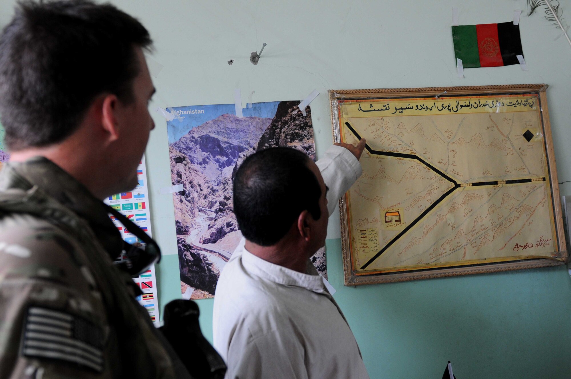 Din Mohammad, Afghan National Police district chief, references security and development projects on a hand-drawn map at the Waze Zadran district center, Paktya Province, Afghanistan Aug. 28. Following the visit, Provincial Reconstruction Team Paktya, with support from the National Geospatial-Intelligence Agency, created and distributed the first-ever Pashto provincial maps for Afghan leadership. (U.S. Air Force photo by 1st Lt. Cammie Quinn, Paktya PRT Public Affairs)