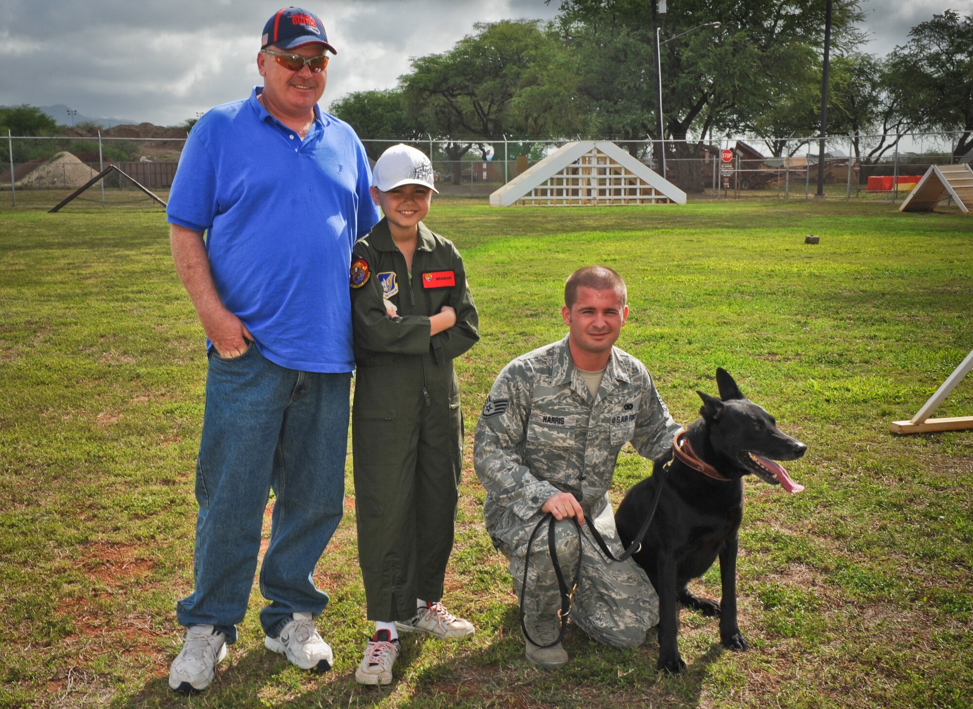 Brandon Whedbee, an 11-year-old leukemia patient poses with his father, Joe Whedbee and Staff Sgt. Larry Harris, military working dog handler with the 647th Security Forces Squadron, Feb. 17 on Joint Base Pearl Harbor-Hickam, Hawaii. Leukemia is one of several cancers of the bone marrow that prevent the normal manufacture of red and white blood cells and platelets, resulting in anemia, increased susceptibility to infection, and impaired blood clotting. (U.S. Air Force photo/Senior Airman Lauren Main)