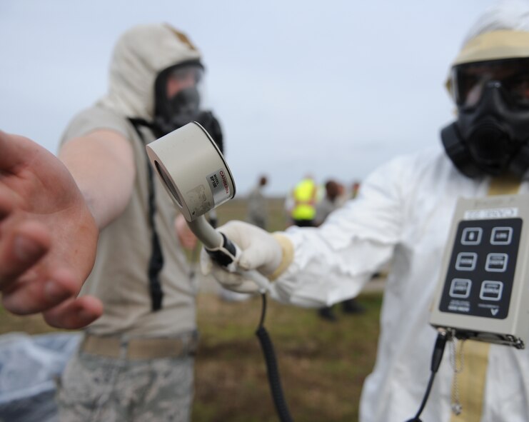 An Airman from the 2nd Civil Engineer Squadron checks a firefighter for radiation contamination during an exercise on Barksdale Air Force Base, La., Feb. 16. The exercise helped emergency personnel receive first-hand experience on how to handle an aircraft accident with nuclear weapons on board. (U.S. Air Force photo/Airman 1st Class Micaiah Anthony)(RELEASED)