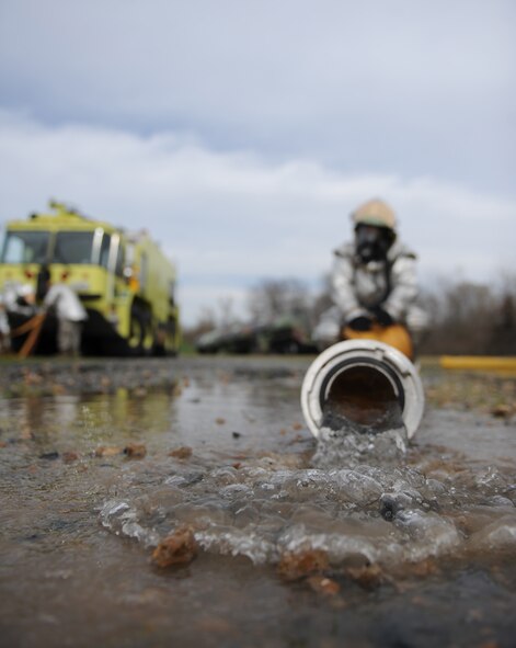 Water seeps out of a fire hose as firefighters from the 2nd Civil Engineer Squadron pack up their gear after extinguishing a mock aircraft fire on Barksdale Air Force Base, La., Feb. 16. In order for a fire hose to be stored efficiently, the water in the hose needs to be drained and the hose must be rolled or stacked neatly to fit back inside the fire truck. (U.S. Air Force photo/Airman 1st Class Micaiah Anthony)(RELEASED)