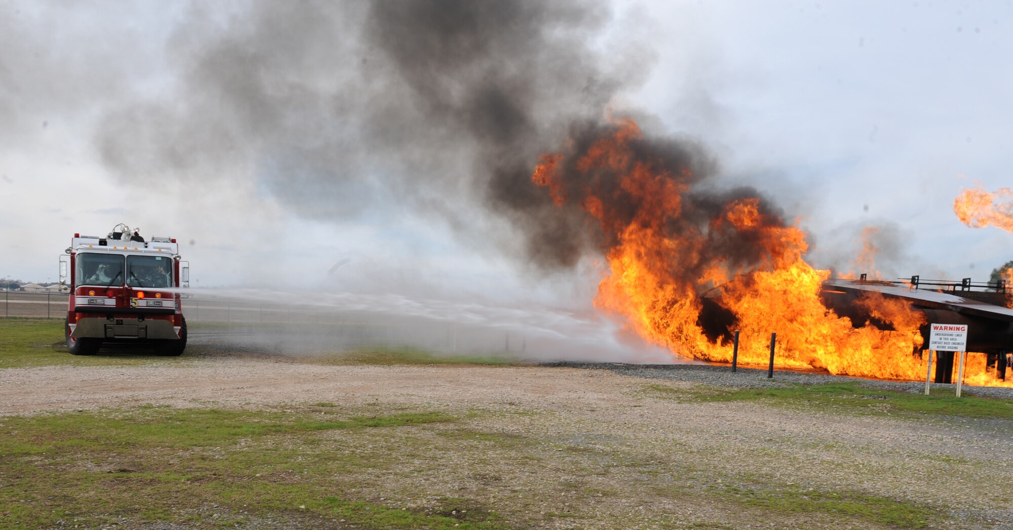 A fire truck douses a mock aircraft with water on Barksdale Air Force Base, La., Feb. 16. Firefighters from the 2nd Civil Engineer Squadron used the trucks to drench the burning aircraft as they approached the scene to save time and help extinguish the blaze. (U.S. Air Force photo/Airman 1st Class Micaiah Anthony)(RELEASED)