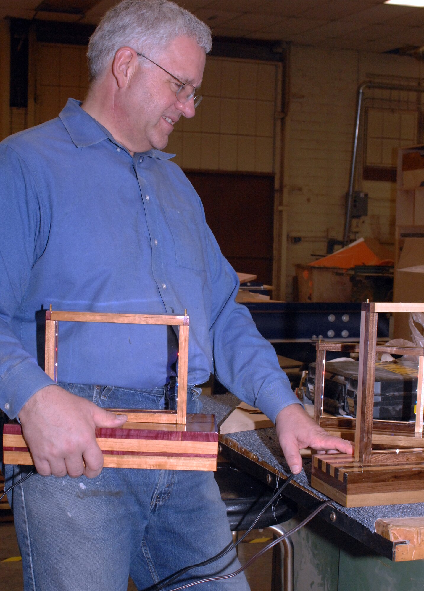 A Team Barksdale member shows off his nearly finished project at the Hobby Shop on Barksdale Air Force Base, La., Feb. 15. His project will soon house military challenge coins and is made of various types of wood. (U.S. Air Force photo/Airman 1st Class Joseph A. Pagán Jr.)(RELEASED)