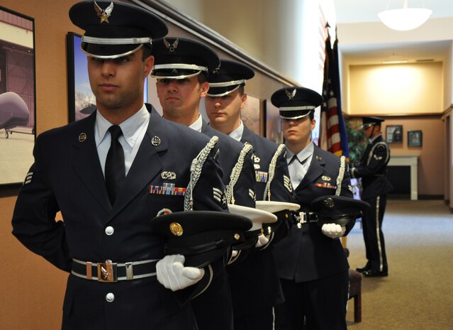 Members of the Beale honor guard prepare the Prisoner Of War/Missing In Action table at the National Prayer Luncheon at Beale Air Force Base, Calif., Feb. 16, 2012. Each branch of the military is recognized by their service cap at the remembrance table. (U.S. Air Force photo by Staff Sgt. Robert M. Trujillo/Released)