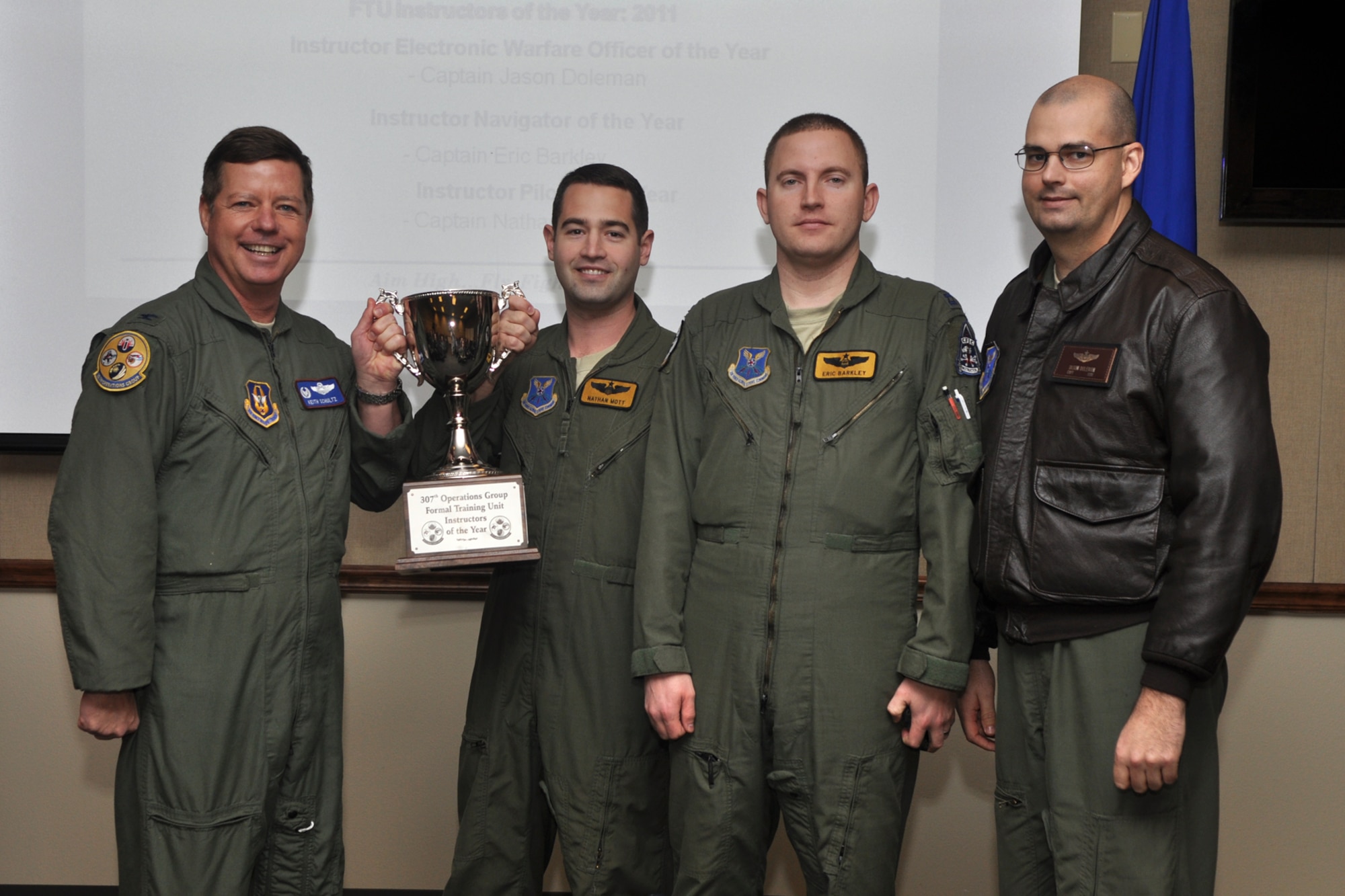 Col. Keith Schultz, commander of the 307th Operations Group, recognizes Captains Nathan Mott, Eric Barkley and Jason Doleman for their accomplishments as the Formal Training Unit’s Instructors of the Year 2011, at the 93rd Bomb Squadron building on Barksdale Air Force Base, La., Feb. 17, 2012. Mott is the “Instructor Pilot of the Year,” Barkley, the “Instructor Radar Navigator of the Year,” and Doleman is the “Instructor Electronic Warfare Officer of the Year.” All three captains are from the 11th Bomb Squadron at Barksdale. (U.S. Air Force photo by Master Sgt. Jeff Walston)