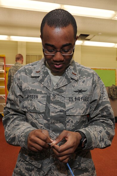 2nd Lt. Freddie Johnson, 744th Communication Squadron cyber infrastructure officer in charge, splices ethernet cords Feb. 17 at Francis T. Evans Elementary School, Clinton, Md. Johnson, Joint Base Andrews, Md. makes sure each wire is connected in the right place in the computer for it to function properly. (U.S. Air Force photo by Staff Sgt. Christopher Ruano)