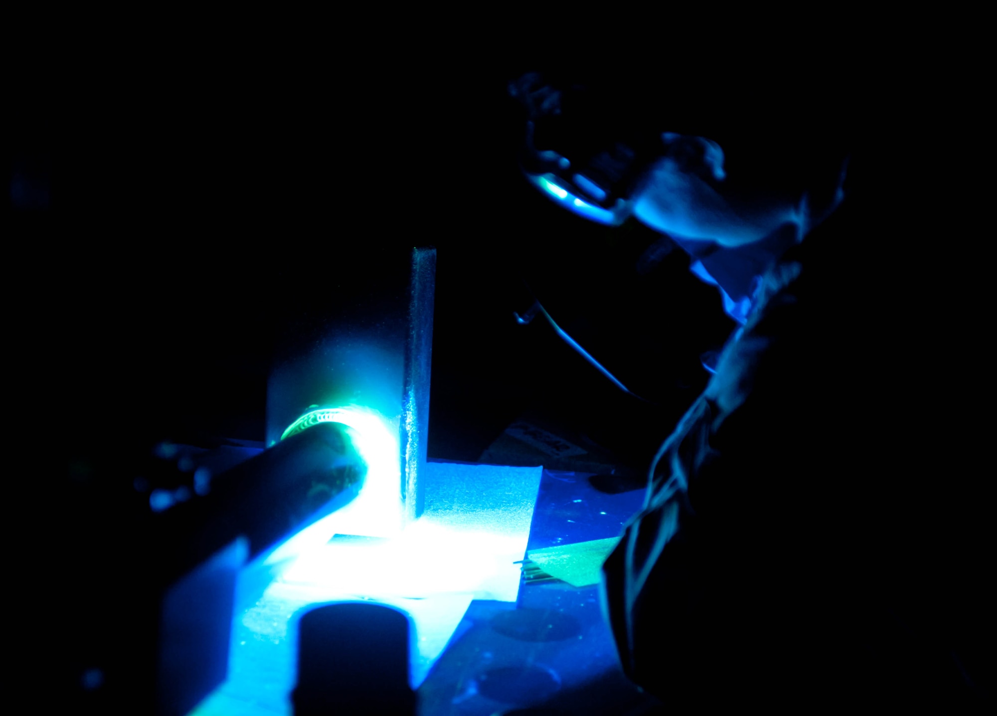 Airman 1st Class Samantha Watkins, 28th Maintenance Squadron non-destructive inspection apprentice, examines a weapons pylon lift assembly for cracks with a ultra-violet lamp during an inspection at Ellsworth Air Force Base, S.D., Feb. 10, 2012. Airman Watkins tests the integrity of the part’s weld area due to the high stress load. (U.S. Air Force photo by Airman 1st Class Zachary Hada/Released)