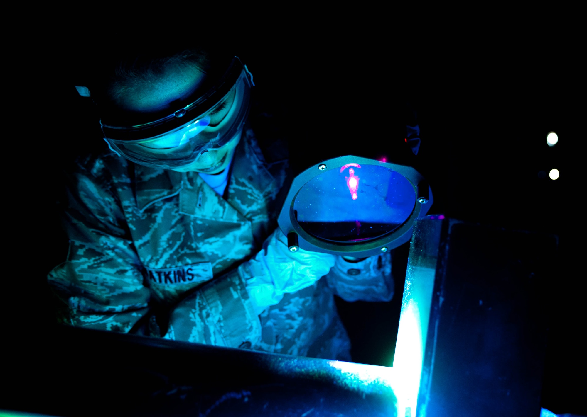 Airman 1st Class Samantha Watkins, assigned to the 28th Maintenance Squadron, inspects a weapons pylon lift assembly for cracks with a Ultra-violet lamp during an inspection at Ellsworth Air Force Base, S.D., Feb. 10, 2012. Airman Watkins has been a non-destructive inspection technician for nearly a year. (U.S. Air Force photo by Airman 1st Class Zachary Hada/Released)