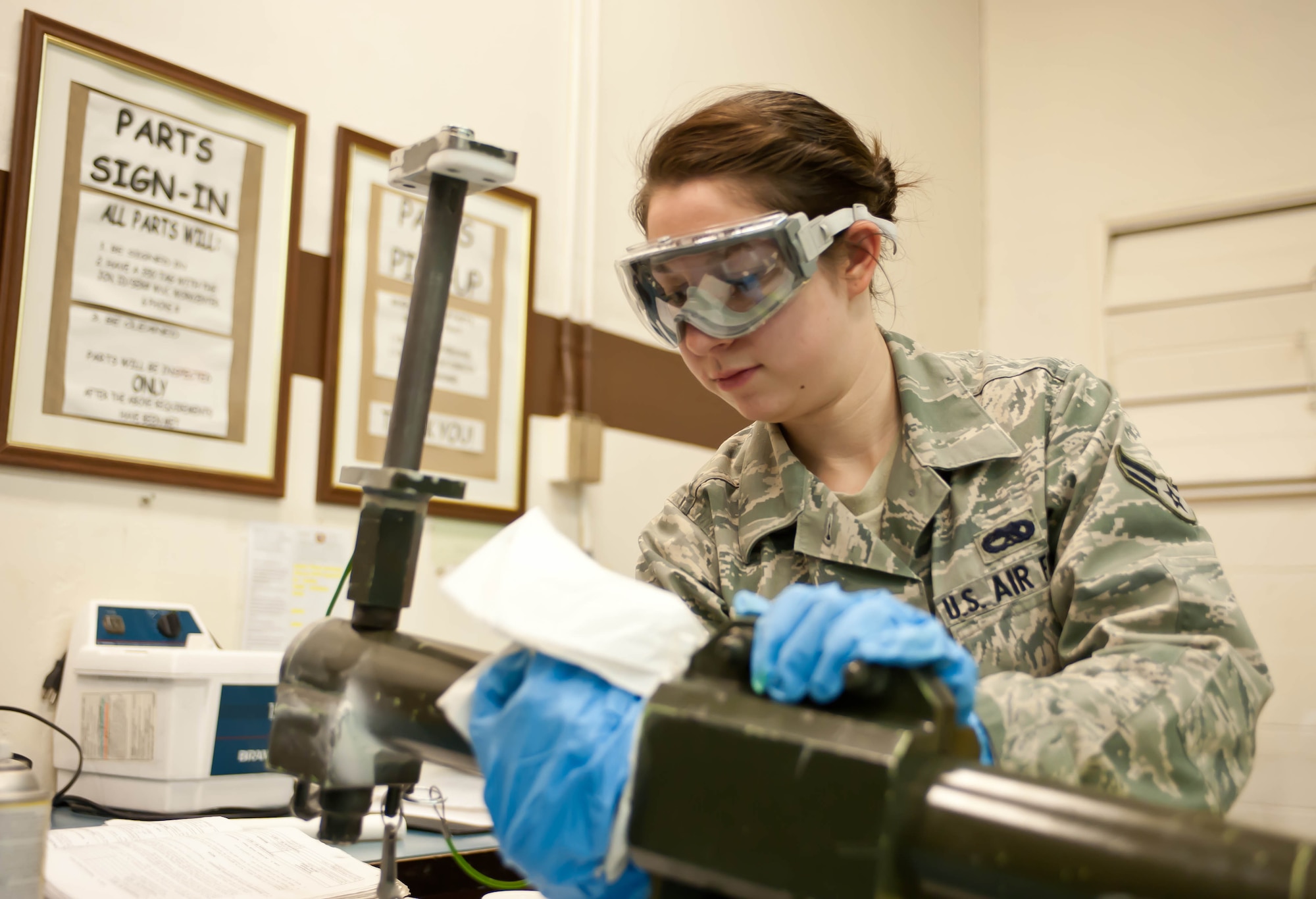 Airman 1st Class Samantha Watkins, 28th Maintenance Squadron non-destructive inspection apprentice, removes excess penetrant from a weapons pylon lift assembly prior to ultra-violet inspection at Ellsworth Air Force Base, S.D., Feb. 10, 2012. The penetrant allows cracks to be visible under UV lamps and allows technicians to identify metal inconsistencies and flaws that may occur due to daily operations. (U.S. Air Force photo by Airman 1st Class Zachary Hada/Released)